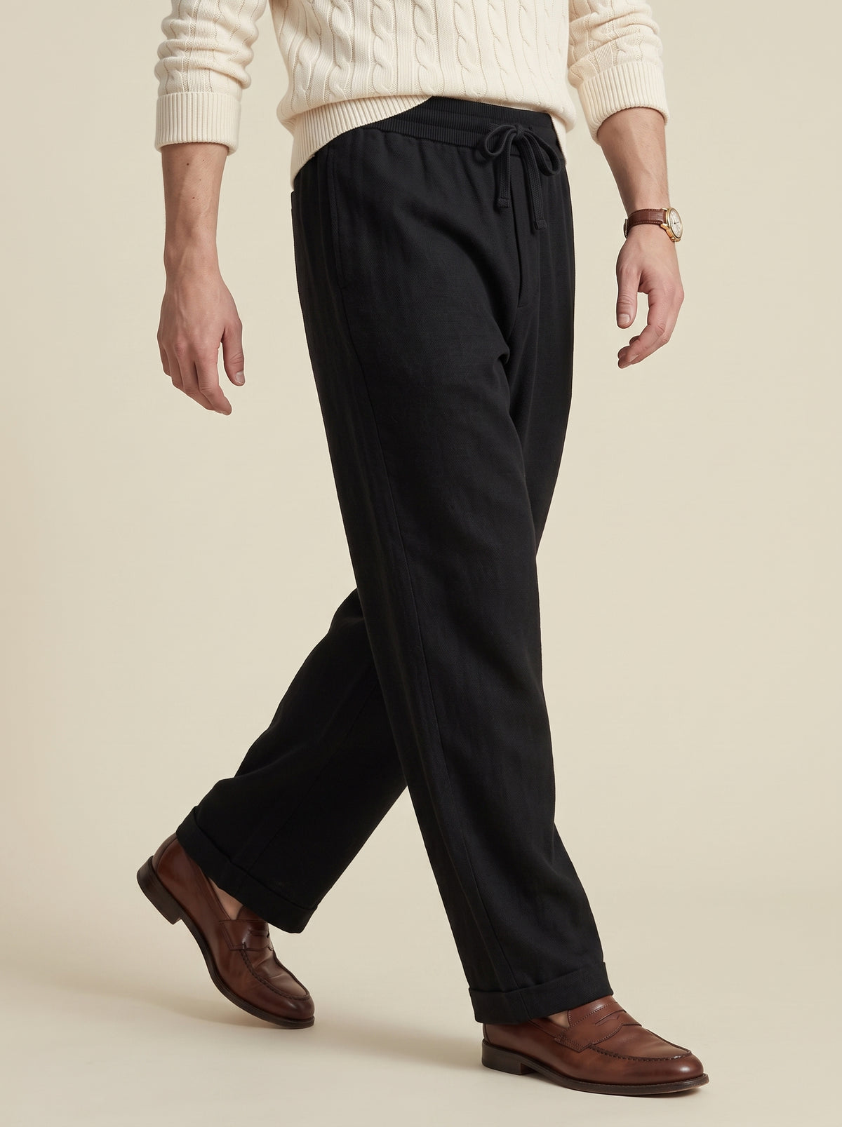 #Jet-Black_group A person wearing black drawstring trousers, a cream ribbed sweater, and brown leather loafers, shown from the waist down against a plain beige studio background.