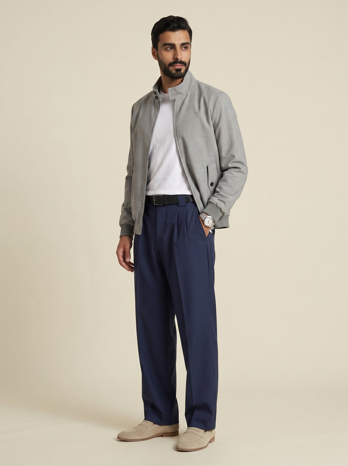#Charcoal-Grey_group A man modeling a light gray zip-up jacket, navy blue trousers, a white t-shirt, and beige loafers against a solid beige studio background.