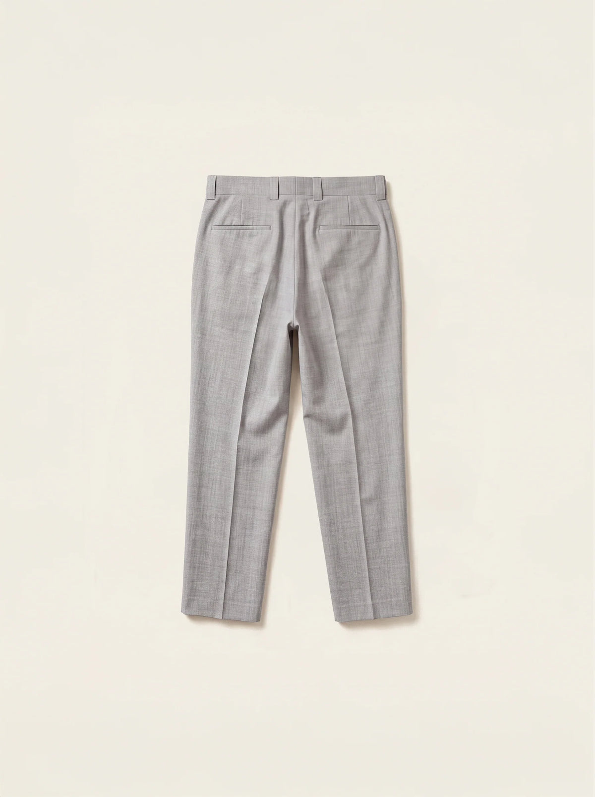 #Silver-Grey_group A pair of light gray textured trousers shown from the back, laid flat on a warm off-white background.